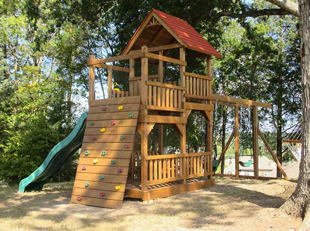 Super tower with rock wall, monkey bar attachment, and picnic tables, and slide