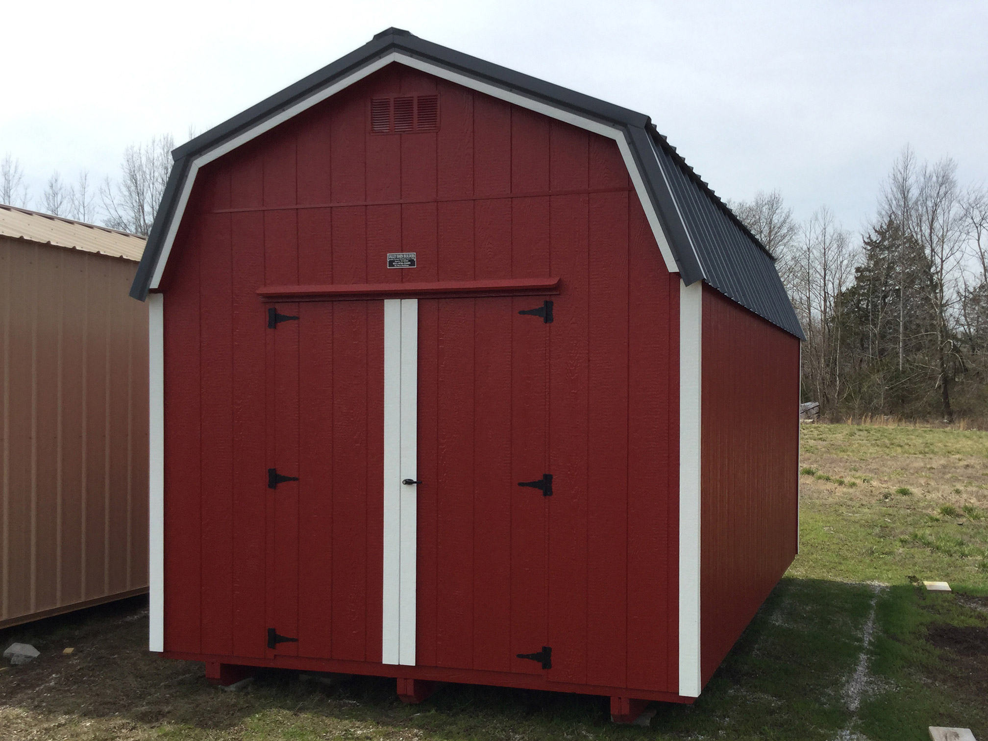 Red, White, and charcoal wood highwall barn with 2 lofts, and a window