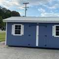 10x20 Wood Utility Cabin. Distance Walls, White Trim and a Polar White Metal Roof. Includes 60" Double Doors, 2 - Windows, 2 - Pair of Shutters, 2 - 4' Lofts and Foil on Roof Only.